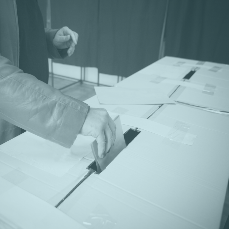 Hand putting paper in a box like voting for elections