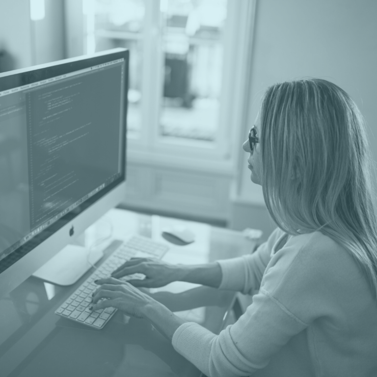 Image of a woman sitting at desk with computer typing