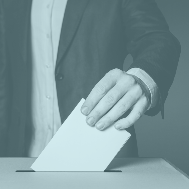 Image of man in suit putting ballot in voting box