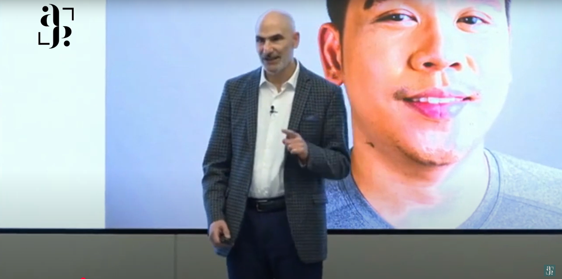 CEO Luis Miguel stands in front of a presentation with a face of a young man as he shares his avantpage story