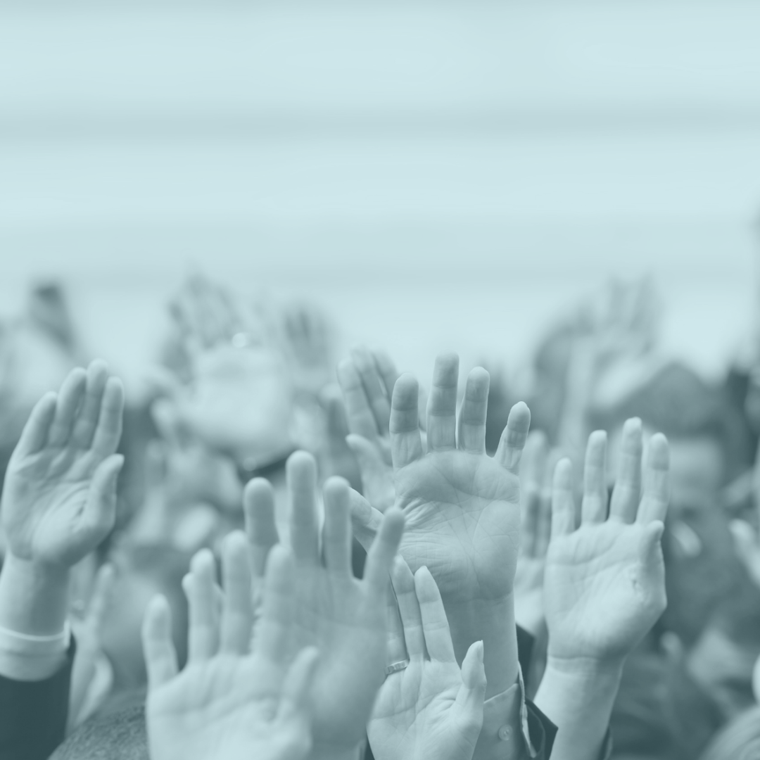 elections photo of lots of hands raised in the air as if voting