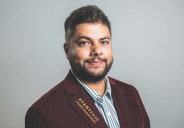 Photo of Jorge Villafuerte looking straight at camera with an Avantpage branded blazer and smiling slightly