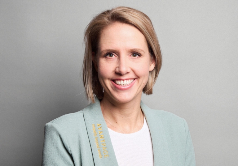 Photo of Vera Hooijdonk looking directly at camera and smiling with hair down, while wearing an Avantpage branded blazer