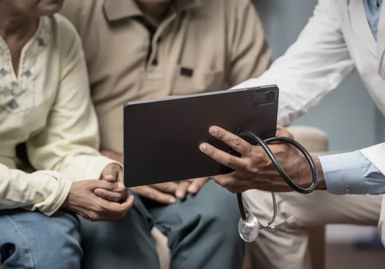 Doctor holding a tablet up to patients so they can consult with their on-demand interpreter.